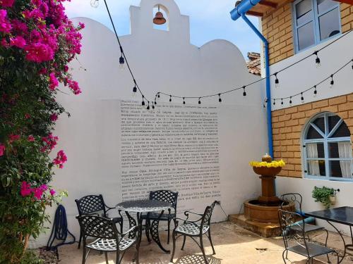 Hotel Casa Boutique Villa de Leyva في فيلا دي ليفا: فناء فيه طاولات وكراسي امام مبنى