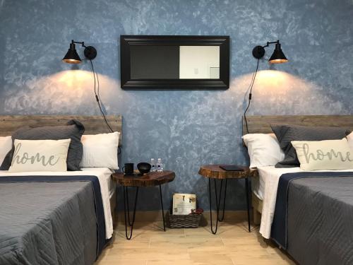 a bedroom with two beds and a mirror on the wall at Garden Suites Comalcalco in Comalcalco