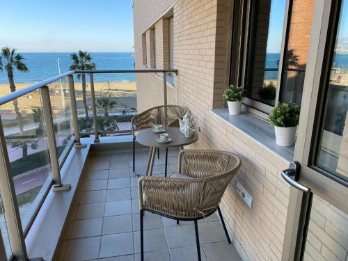 balcón con mesa, sillas y vistas al océano en Playa Pacífico Apartment en Málaga