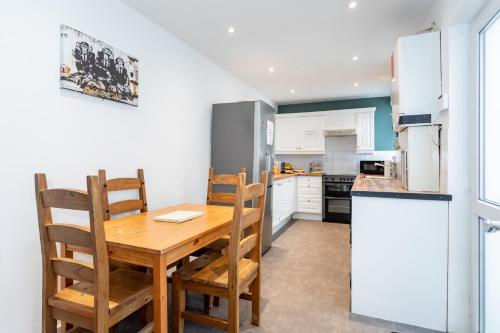 a kitchen with a wooden table and chairs and a refrigerator at Castlereagh guest House in Belfast