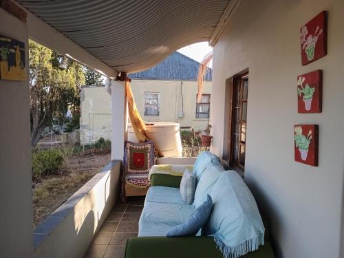 un portico con un divano blu su un patio di Karoo Cottage Comfort in Uniondale a Uniondale