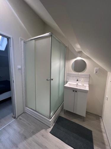 bagno con doccia in vetro e lavandino di Bükkös Apartman a Szentendre