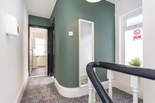 a stairway with a green wall and a mirror at Castlereagh guest House in Belfast