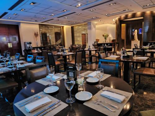 a restaurant with tables and chairs with wine glasses at Regal Pacific Puerto Madero in Buenos Aires