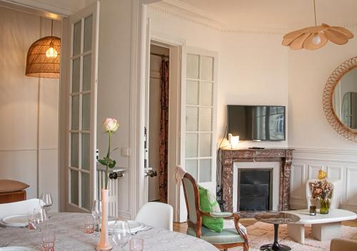 salon ze stołem i kominkiem w obiekcie Rare! Magnifique appartement - Vue Cathédrale w mieście Reims