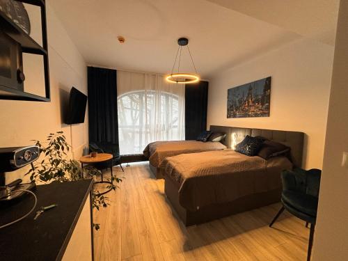 a hotel room with two beds and a kitchen at CENTRUM PLAC WOLNOŚCI 6, Faktura VAT, bezkontaktowe zameldowanie in Poznań