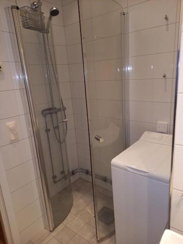 a shower with a glass door in a bathroom at Floravägen 11 in Lidingö