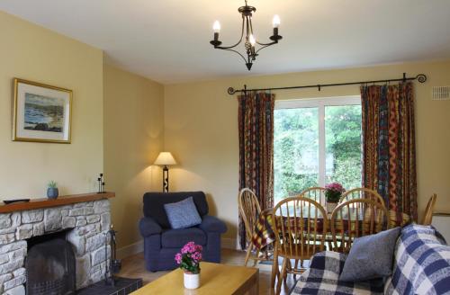 a living room with a fireplace and a table and chairs at Leitrim Quay - Riverside Cottage 9 in Leitrim