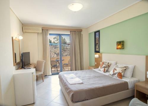 a hotel room with a large bed and a television at Aeolian Gaea Hotel in Skala Kallonis