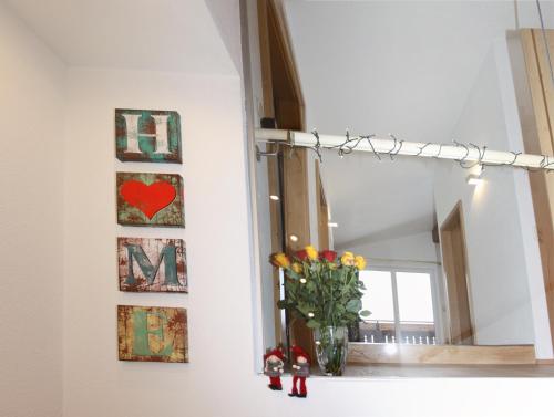 a vase of flowers on a window sill with a mirror at Appartement De Luxe - 140m² in Elbigenalp