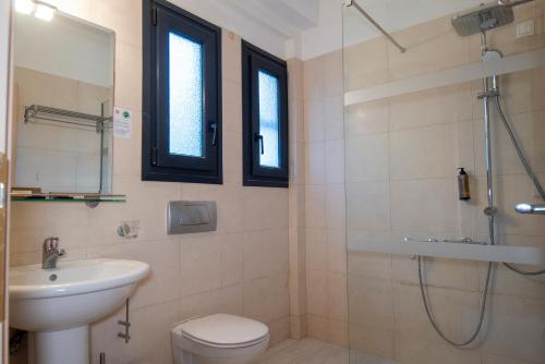 a bathroom with a toilet and a sink and a shower at Aeolian Gaea Hotel in Skala Kallonis