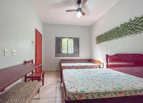 een slaapkamer met 2 bedden, een tafel en een plafondventilator bij Chácara privativa em condomínio! in Pôrto Feliz