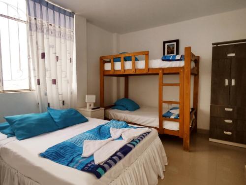 帕拉卡斯的住宿－Hospedaje El Candelabro de Paracas，一间卧室配有两张双层床和蓝色枕头
