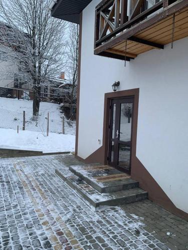 a door to a building with snow on the ground at Ехо Тростяну in Slavske