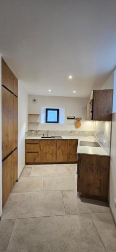 une grande cuisine avec des placards en bois et un évier dans l'établissement Maison, à Beyrède-Jumet