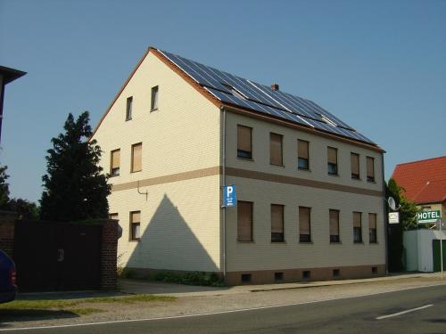 een groot wit gebouw met zonnepanelen erop bij Hotel Garni Kochstedt in Dessau