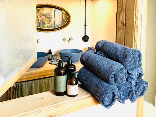 a bathroom counter with towels and two bottles of wine at Medemaistro in Faver