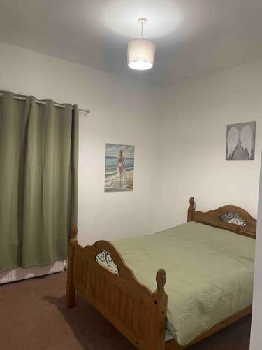 a bedroom with a wooden bed and a window at Sage Home - sweet & snuggly in Denton