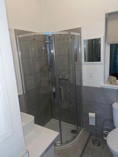 a shower with a glass door in a bathroom at Sage Home - sweet & snuggly in Denton