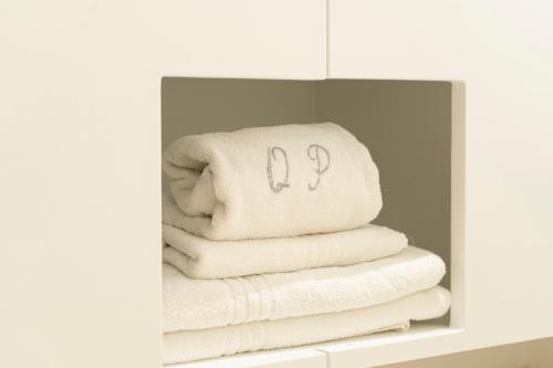a stack of white towels in a bathroom mirror at Quinta Do Passal in Paços de Ferreira