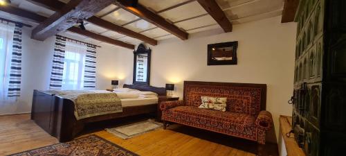 1 dormitorio con 1 cama, 1 sofá y 1 silla en Pincedombi, en Cserépfalu
