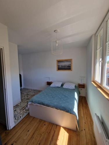une chambre avec un lit et un lustre dans l'établissement maisonnette, à Dieppe
