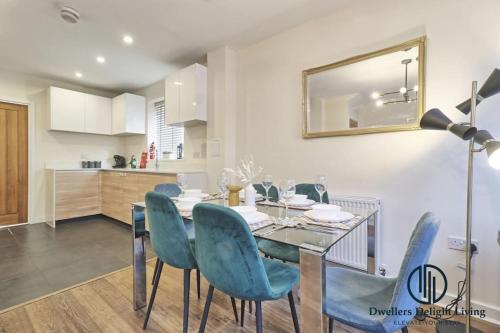 a dining room with a glass table and blue chairs at Stylish 3Bedrooms 2 Bath in Harold wood Romford in Harold Wood