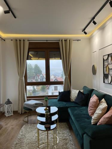 a living room with a green couch and a window at Apartman A&N Zlatibor in Zlatibor