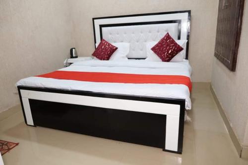 - une chambre avec un grand lit et des oreillers rouges dans l'établissement millenium homestay, à Varanasi