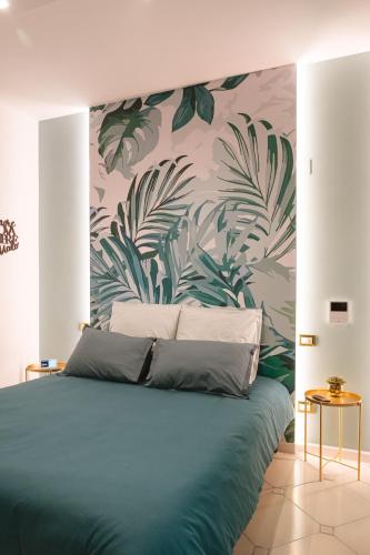 a bedroom with a blue bed with a tropical wallpaper at ALBERGO DIFFUSO Dimora Rossi Charme B&B in Turi