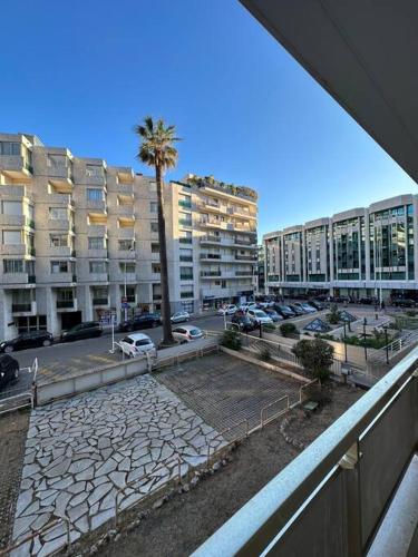- une vue sur un parking avec des bâtiments et un palmier dans l'établissement Appartement « SUITE » Croisette, à Cannes