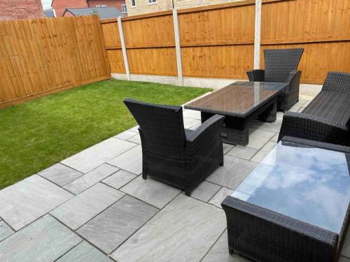 a patio with a table and chairs and a fence at Modern home on the edge of the Cotswolds in Evesham