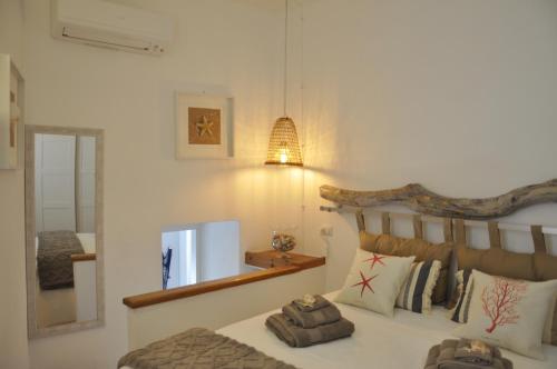 a bedroom with a large bed and a mirror at La Maisonette - Centro storico in La Maddalena