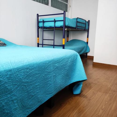 two bunk beds in a room with a wooden floor at Hostal Pampaloja Antof in Antofagasta