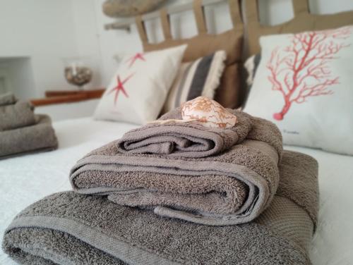 a pile of towels sitting on top of a bed at La Maisonette - Centro storico in La Maddalena