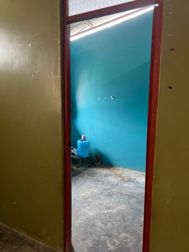 una puerta que conduce a una habitación con una pared azul en Casa de Robin, en Moyobamba