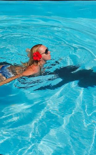 a woman with a red flower in a swimming pool at Green Hill Paradise Villa in Unawatuna