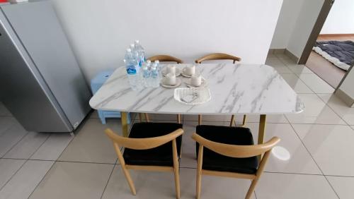 16 Sierra Puchong Zentro 5 人 Supreme二房公寓 في بوتشونغ: طاولة بيضاء بأربعة كراسي وطاولة رخام أبيض