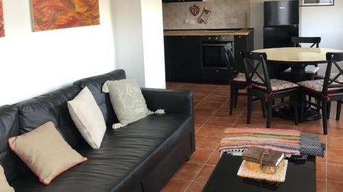 a black leather couch in a living room with a table at Lioda Roccia in Masariè