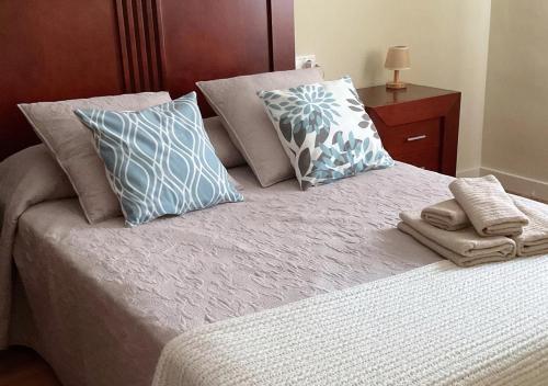 łóżko z niebiesko-białymi poduszkami w obiekcie Casa María w mieście Priego de Córdoba