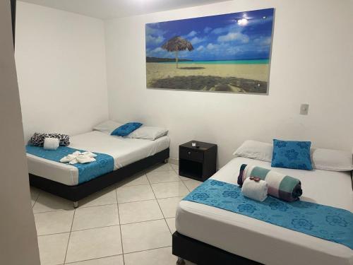 um quarto com duas camas e uma fotografia de um guarda-chuva em Hotel Miami Beach San Jerónimo em San Jerónimo