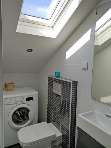 a bathroom with a washing machine and a skylight at Central Sesimbra 26 in Sesimbra