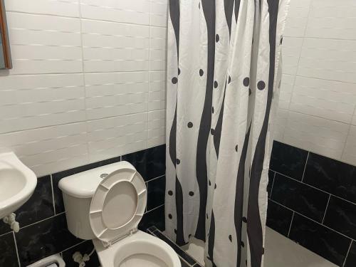 a bathroom with a toilet and a shower curtain at Hotel Miami Beach San Jerónimo in San Jerónimo