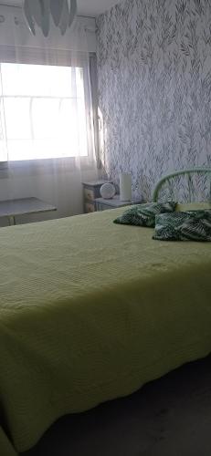 クルル・シュル・メールにあるLe Tridentのベッドルーム1室(緑のシーツが敷かれたベッド1台、窓付)
