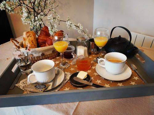 La maison de Mona في قرقشونة: صينية عليها كوبان من القهوة وأكواب من عصير البرتقال