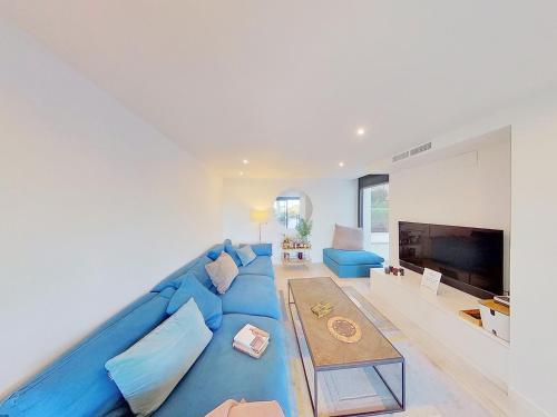 a blue couch in a living room with a tv at Premium Habitat 3 Hermanas in Sant Andreu de Llavaneres