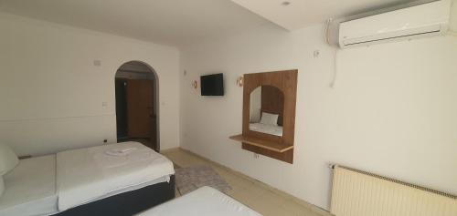 a small room with a bed and a mirror at E & P HOTEL in Tetovo