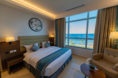a hotel room with a bed and a large window at فندق كورال ريف coral reef hotel in Al Wajh