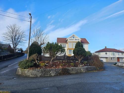 a house with a garden in the middle of a street at Guesthouse Karmøy in Sæveland