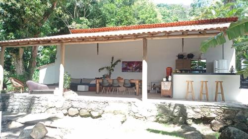 a pavilion with a table and chairs in a yard at Pousada Sobre A Rocha in Praia de Araçatiba